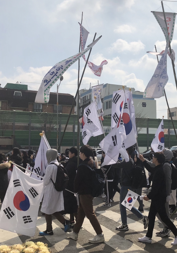 행사에 참가한 학생들이 태극기와 깃발을 들고 행진하고 있다.