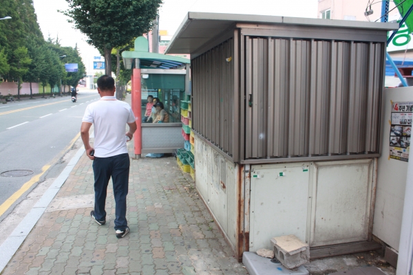 양산시 중앙로 신기주공아파트 버스정류장 옆 인도를 일부 점거하고 있는 옛 토큰박스가 길가에 흉물처럼 방치돼 있다(사진=신정윤 기자)