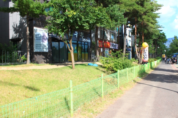 휀스 뒤 건축물 입구가 공공공지쪽을 향하고 있다. 양산시는 본지 보도 후 휀스 앞 벤치를 철거했다.