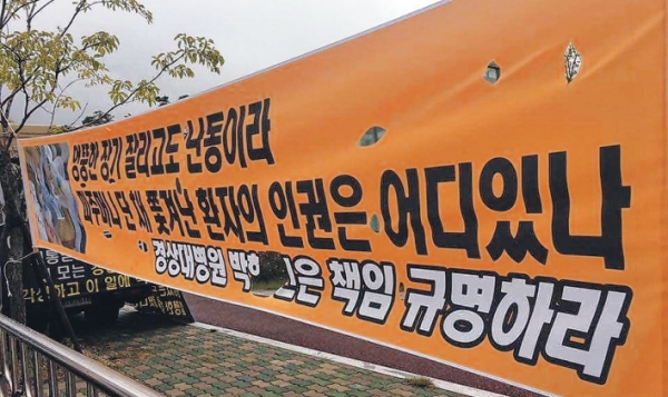 창원경상대학교병원 앞에서 한 환자 가족들이 환자의 퇴원을 거부하며 농성하고 있다.