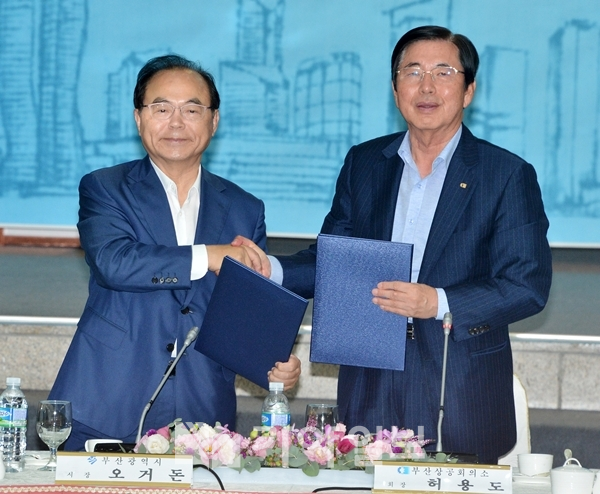 오거돈 부산광역시장과 허영도 부산상공회의소 회장이 지난해 8월 27일 첫 간담회에서 경제활성화를 위한 상생파트너십 선언서를 교환하며 악수하고 있다.(자료사진)