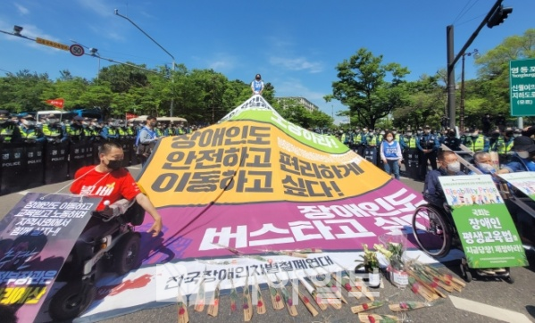 전국장애인차별철폐연대(전장연)가 10일 윤석열 대통령 취임을 맞아 서울 영등포구 여의도공원 앞 도로에서 ‘차별 철폐를 위한 권리선언’ 집회를 열고 있다. 전장연 등은 윤 대통령 취임을 축하한다는 의미에서 ‘장애인 권리 예산 보장’ 등 문구를 붙인 장미꽃과 화분을 준비했다.