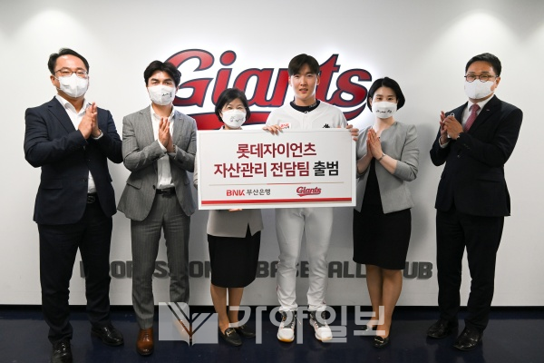 BNK부산은행 허영선 자산관리본부장과 프로야구 롯데자이언츠 최준용 선수가 31일 사직운동장에서 부산은행 ‘롯데자이언츠 자산관리 전담팀’을 출범시켜 스포츠 선수 특성에 맞춘 종합 자산관리 서비스를 제공하는 협약서를 들어보이고 있다.(사진제공=부산은행)
